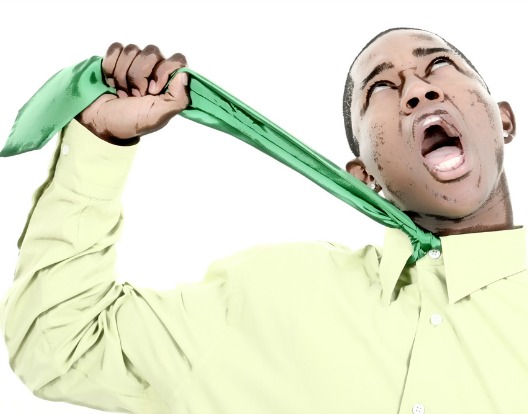 Business Man in green shirt and green tie choking himself. Very funny expression. Shot in studio over white.