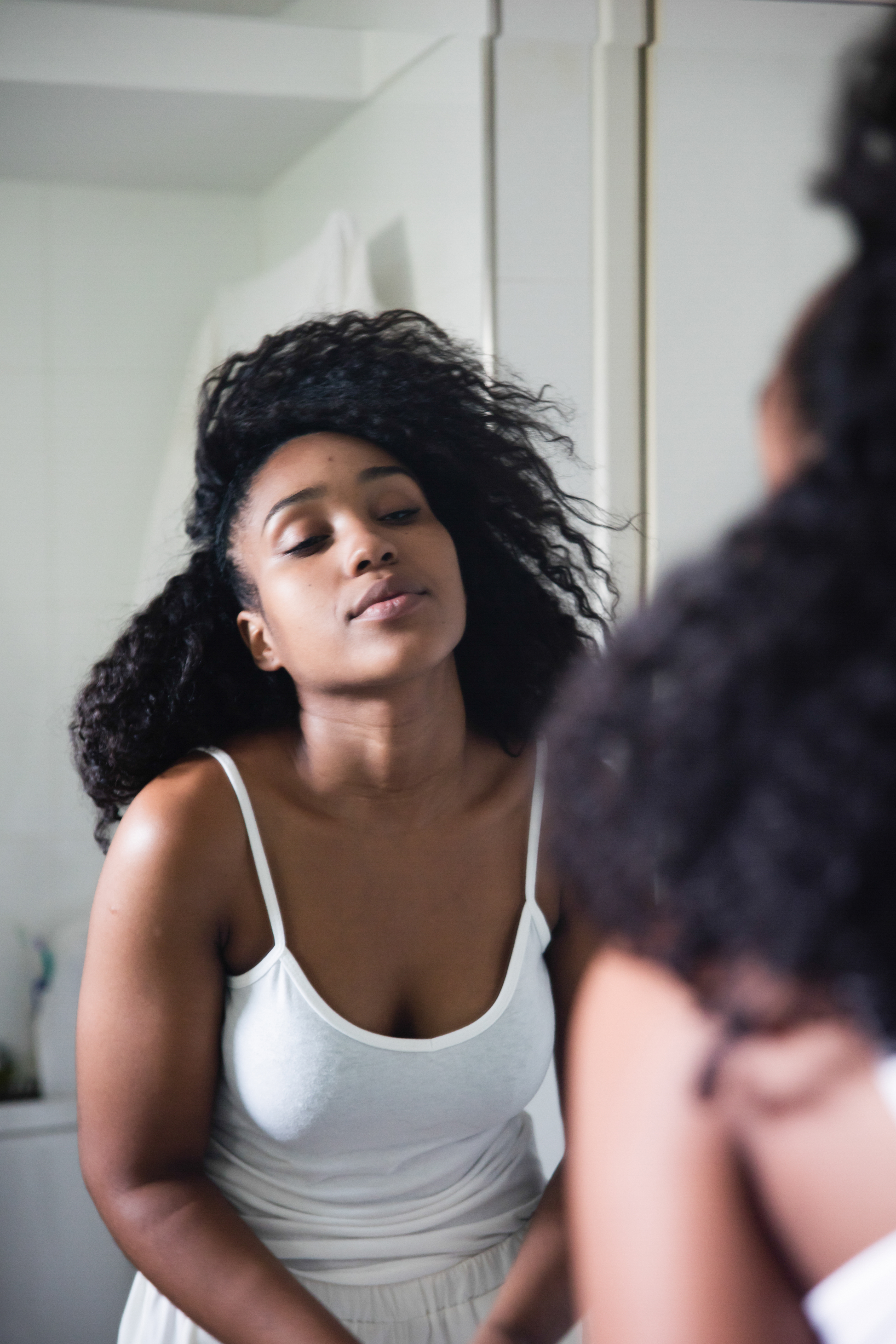 Portrait of pretty black woman looking at the mirror still sleepy