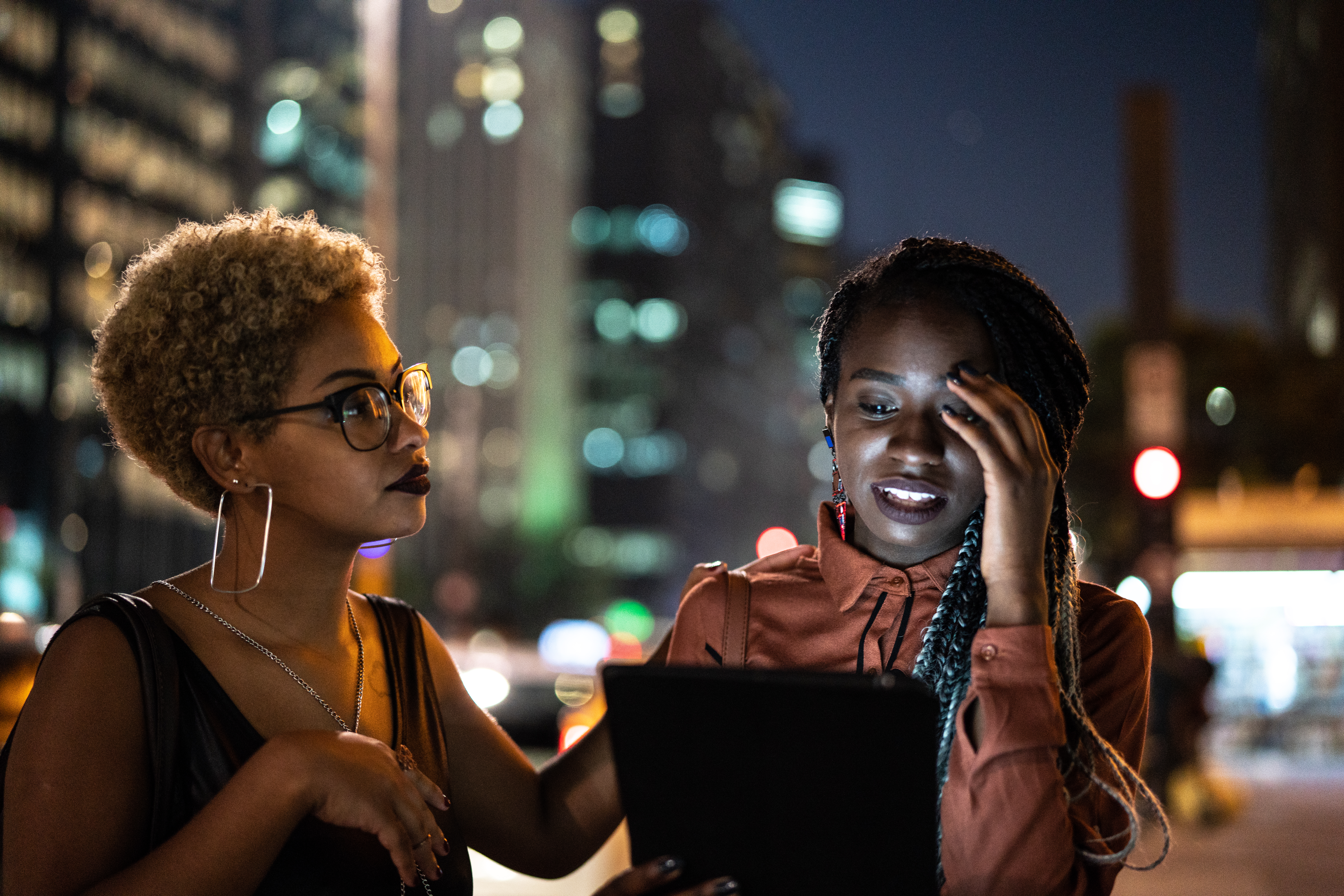 Two Woman Using Tablet at night
