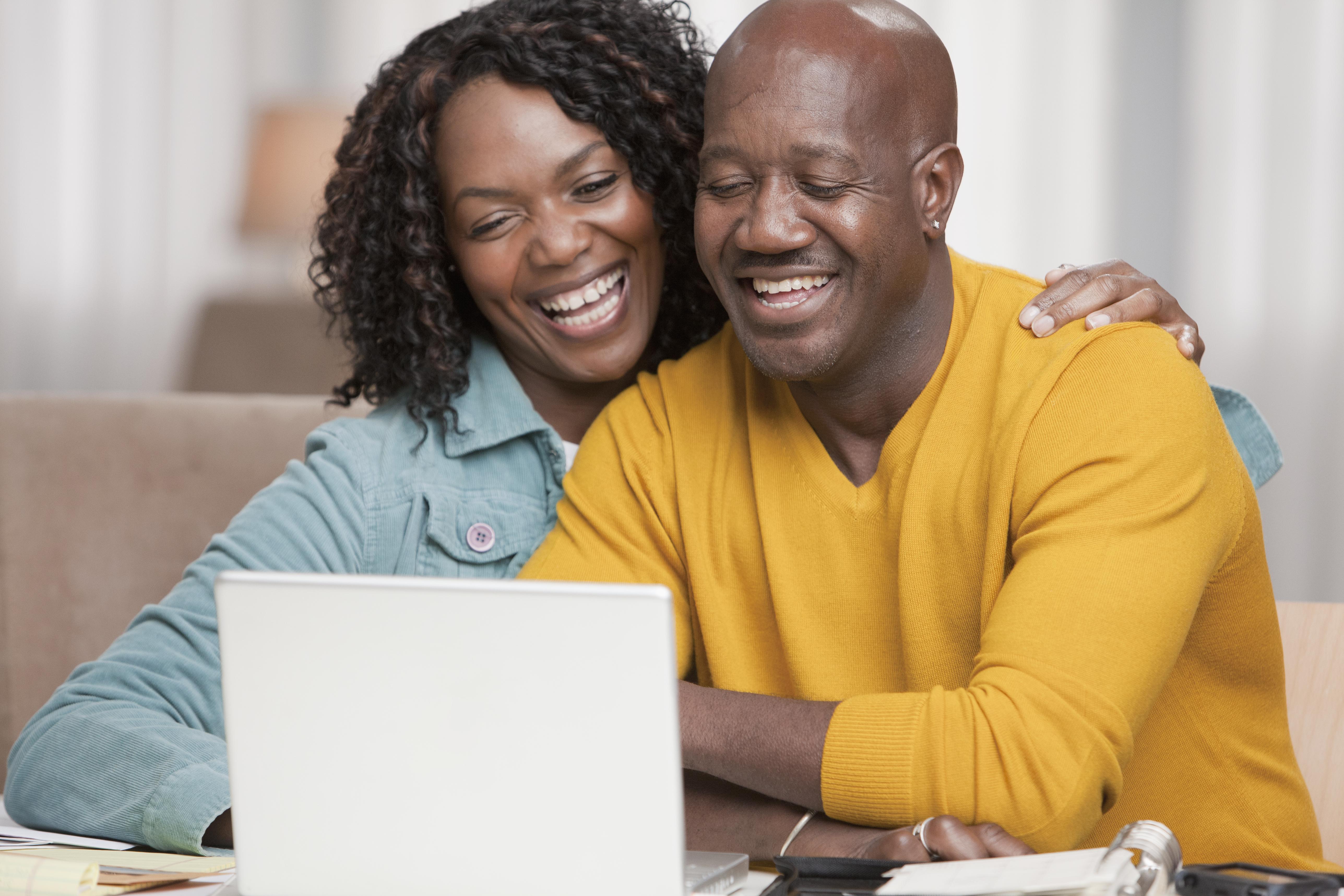 Smiling African American couple using laptop together