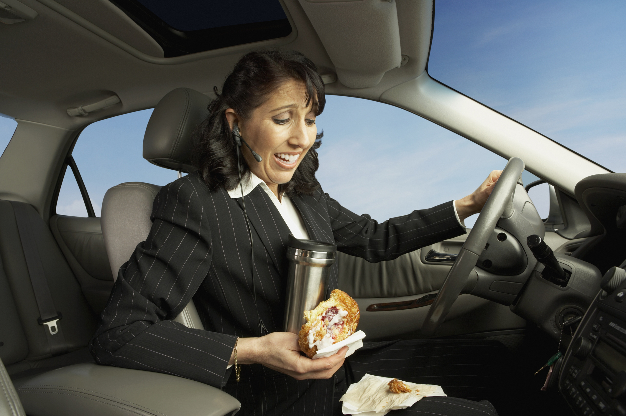 Businesswoman driving and eating