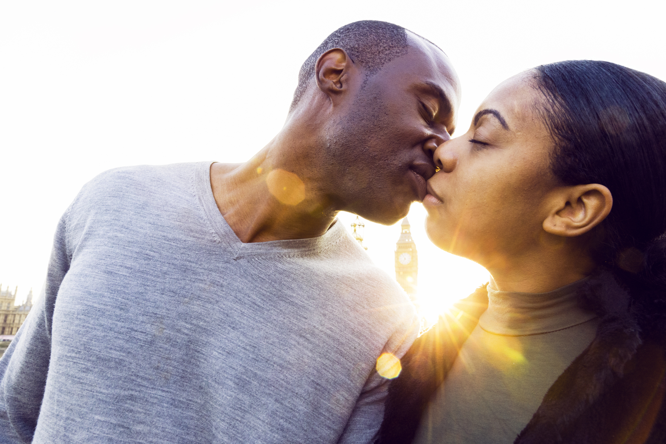 Couple kiss with the setting sun in the background