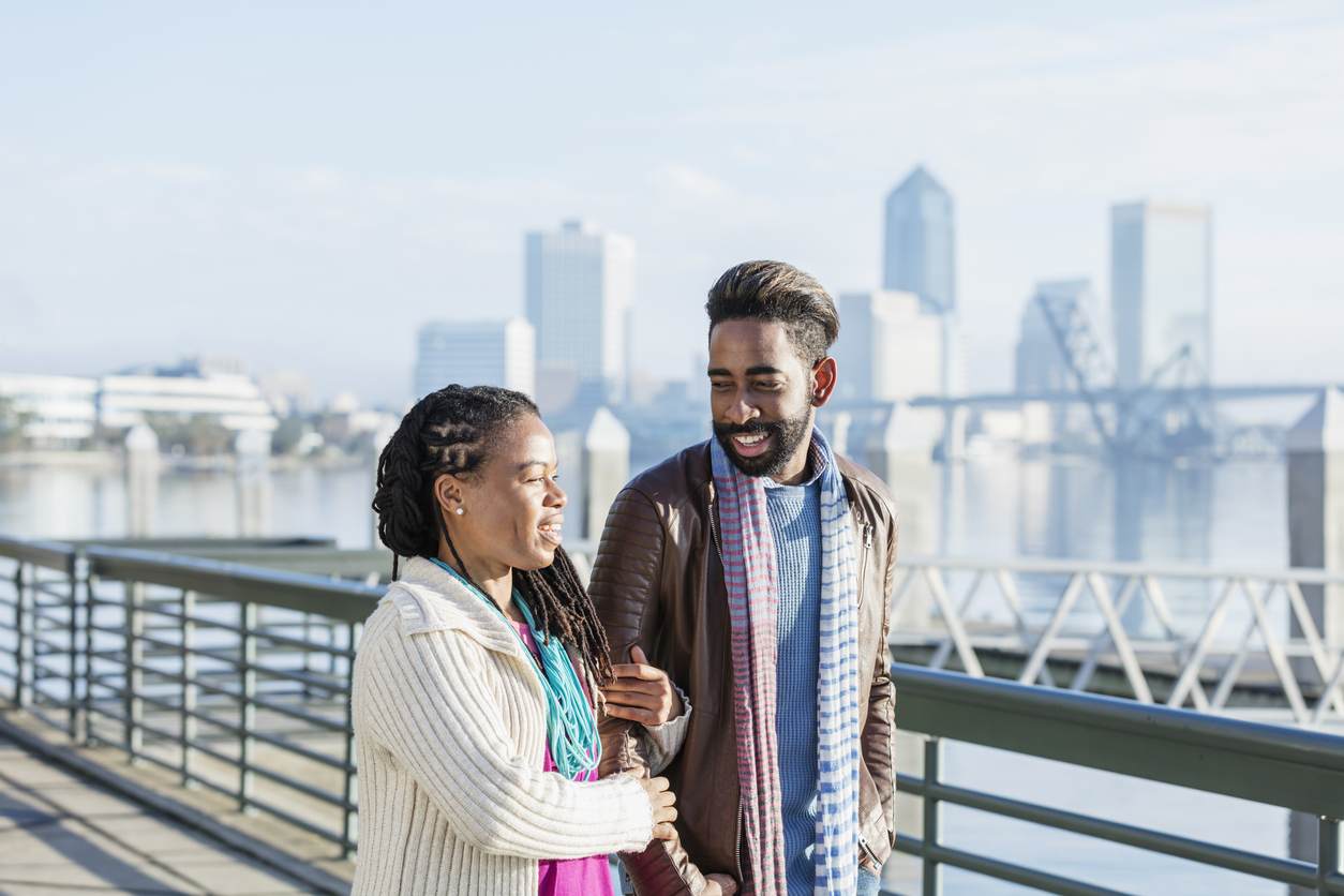 Mixed race couple walking together on a city waterfront