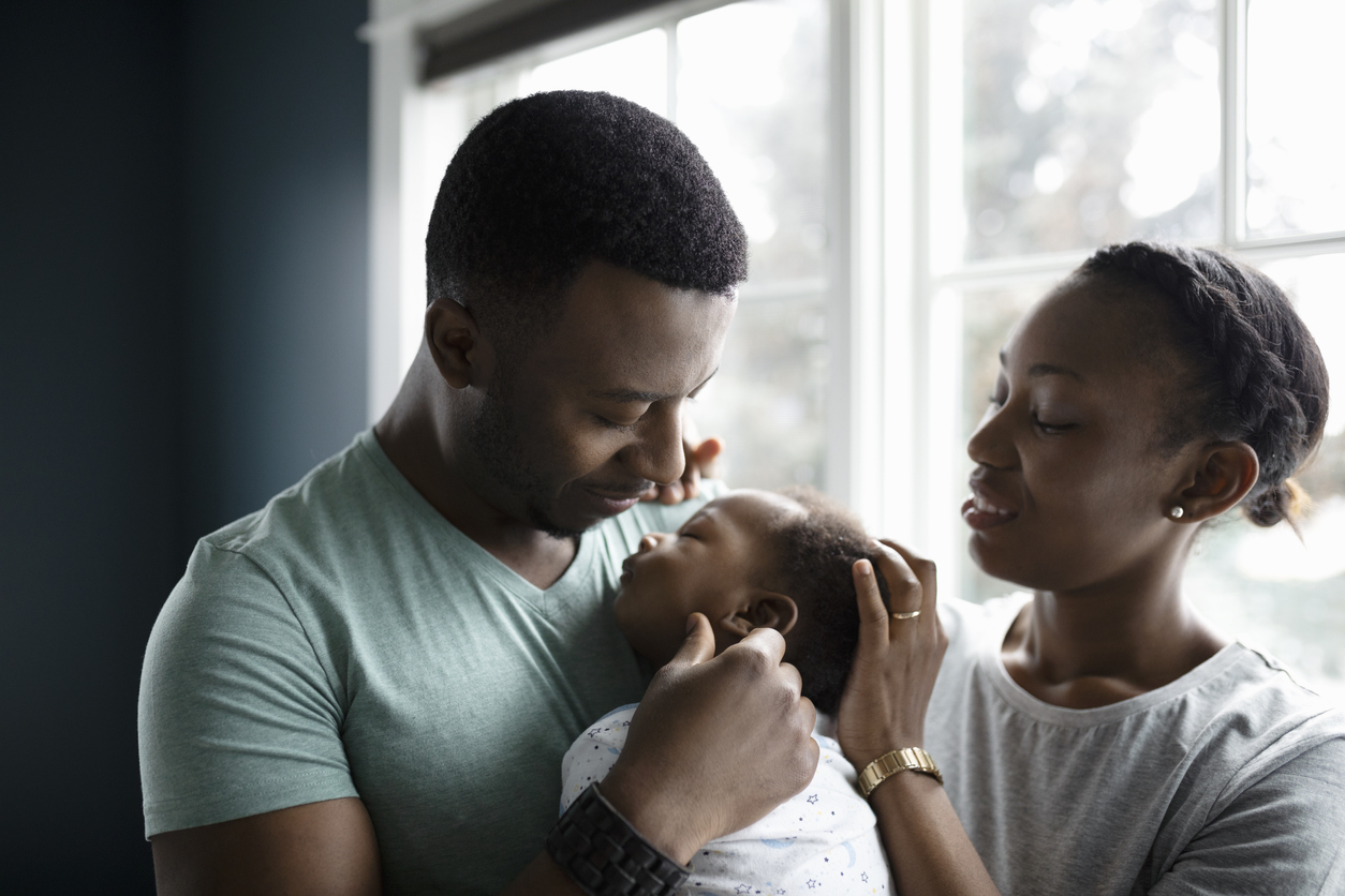 Affectionate parents with sleeping baby son