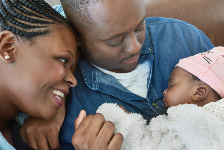 Close-up of parents looking at baby girl on sofa
