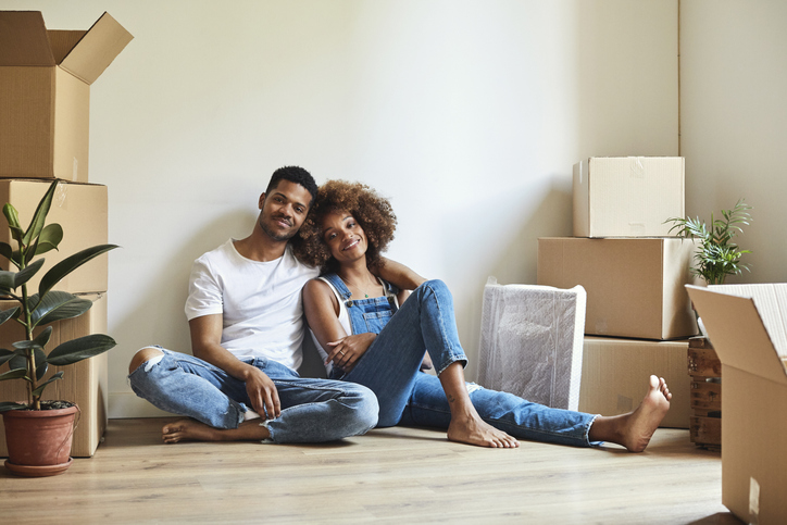 Young couple with moving boxes at new apartment