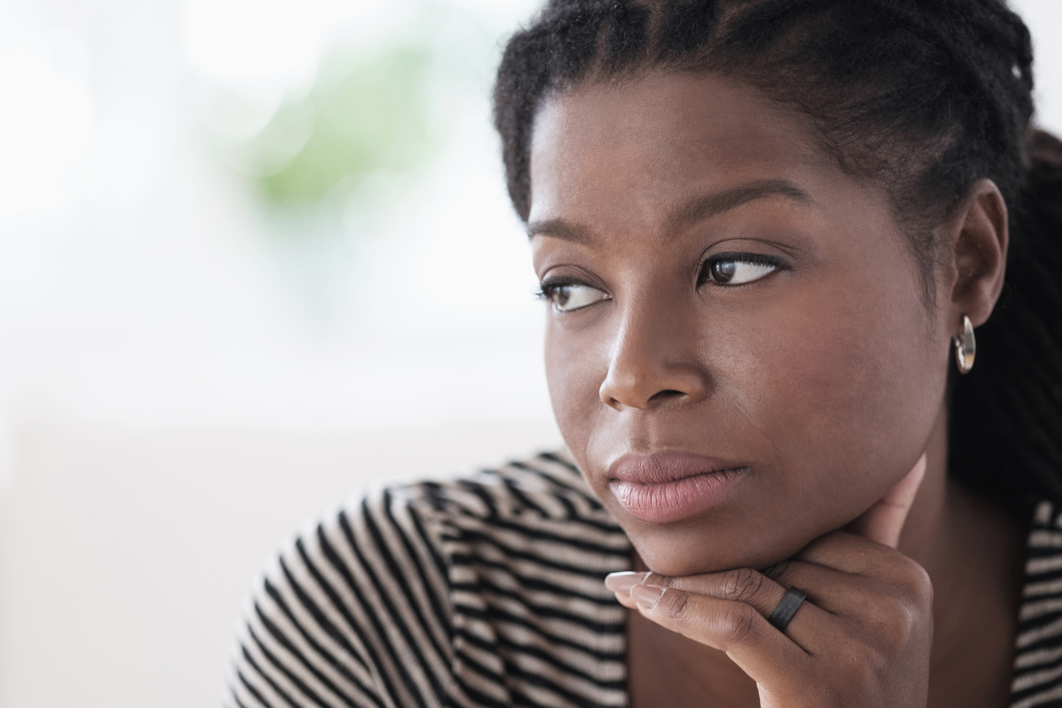 Black woman resting chin in hand