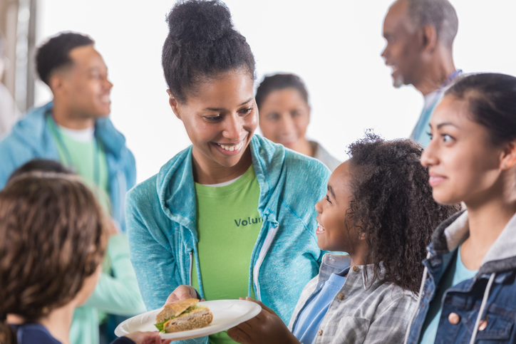 Food bank volunteer offers little girl a meal