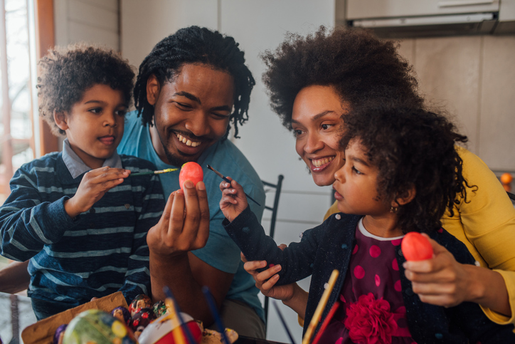 Family with children decorating Easter eggs