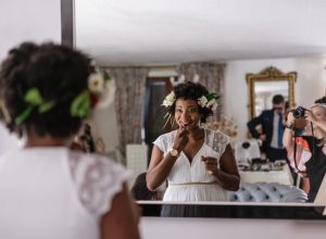 Reflection Of Bride Applying Lipstick While Standing In Front Of Mirror