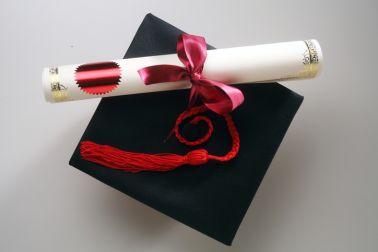 Mortarboard And Diploma On Gray Background