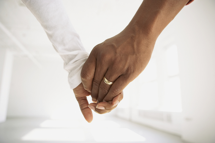 Couple holding hands in empty room