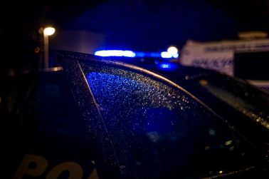 Spain, Madrid, rain falling on the window of police car at night