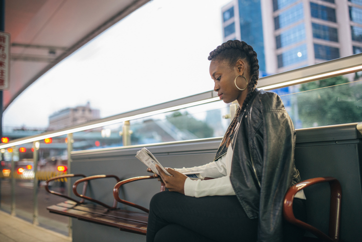 Young black lady reading newspaper