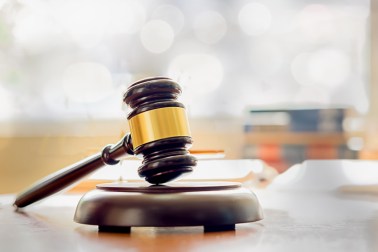 Close-Up Of Gavel On Table In Courtroom