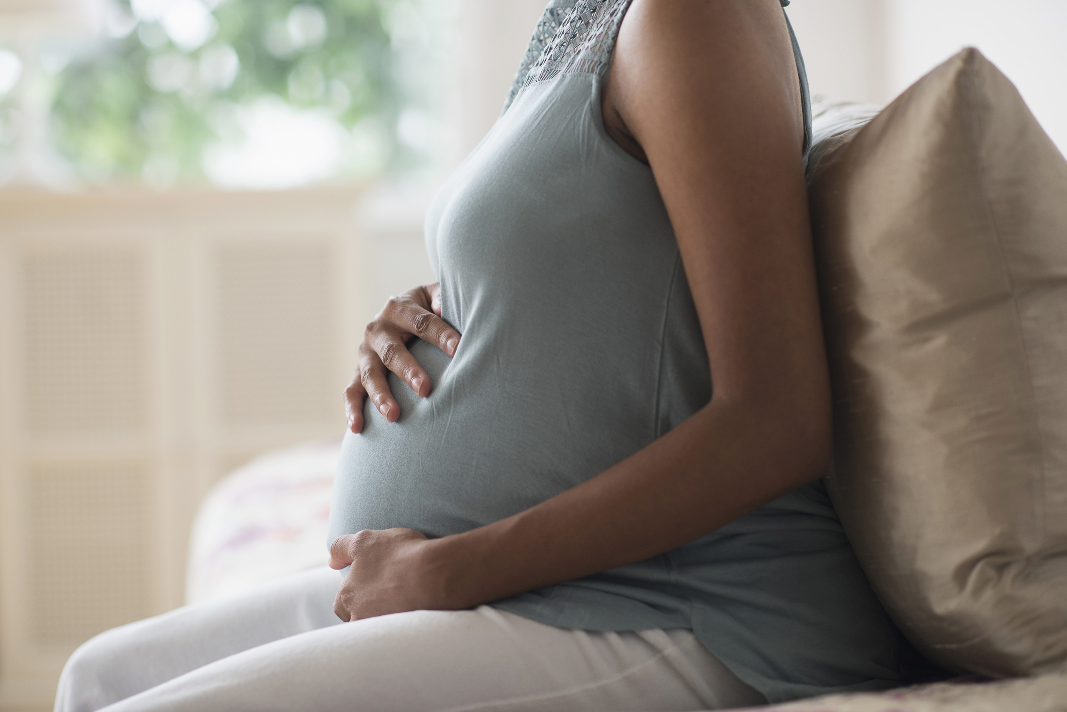 Pregnant African American mother holding her stomach - stock photo