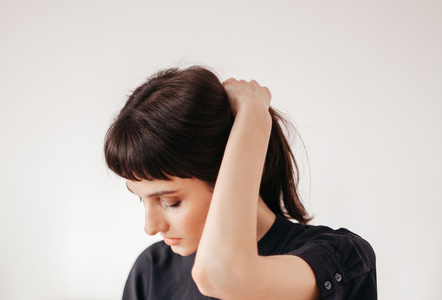 Woman making herself a ponytail hairstyle