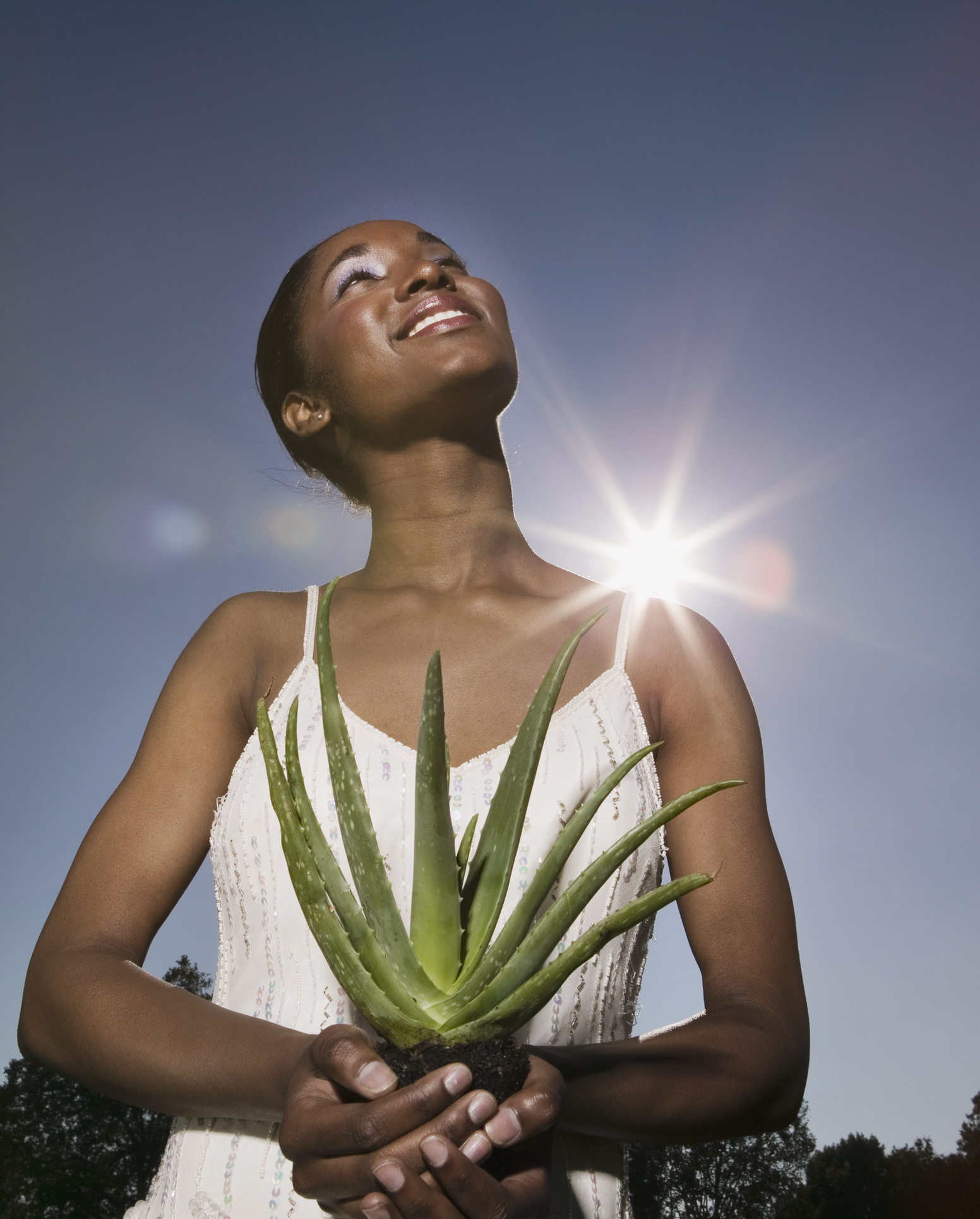 African woman holding aloe plant