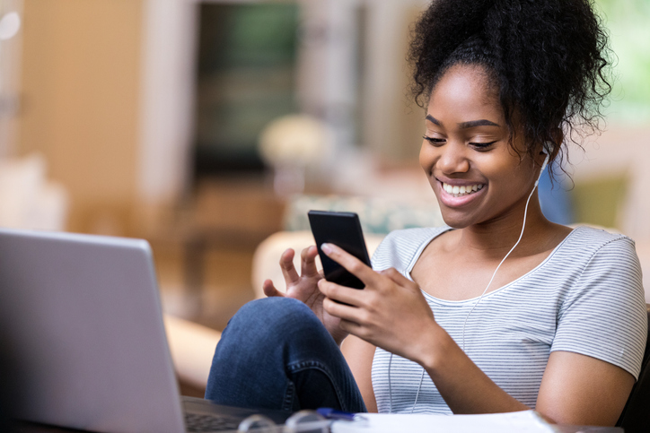 Young woman uses smartphone at home