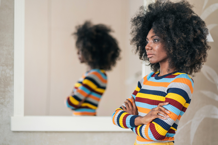 Afro Woman standing in front on the mirror