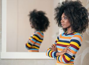 Afro Woman standing in front on the mirror