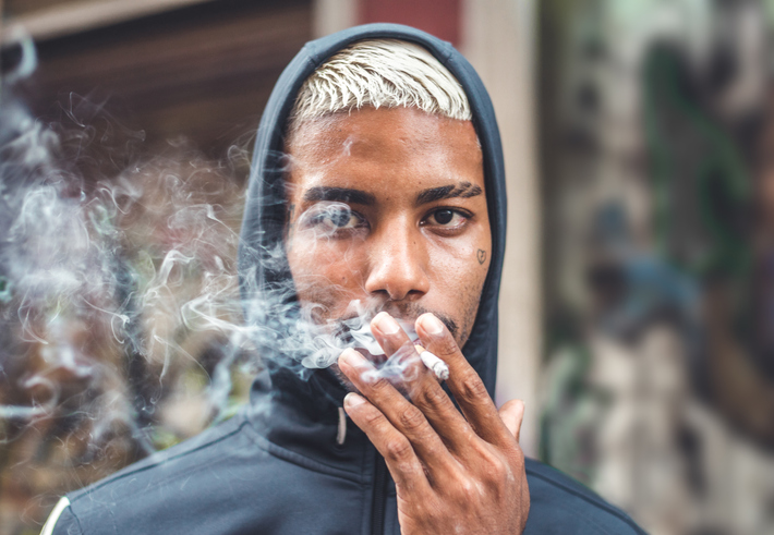 Rebel boy smoking on the street
