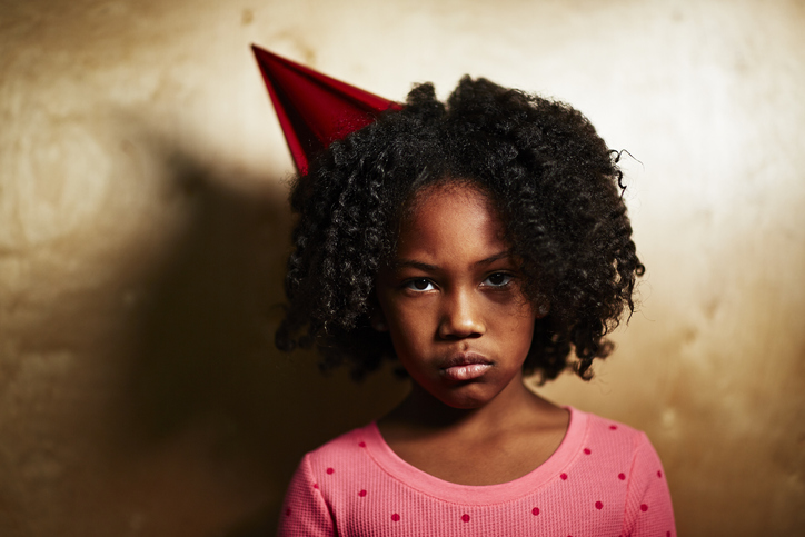 Sad girl wearing party hat