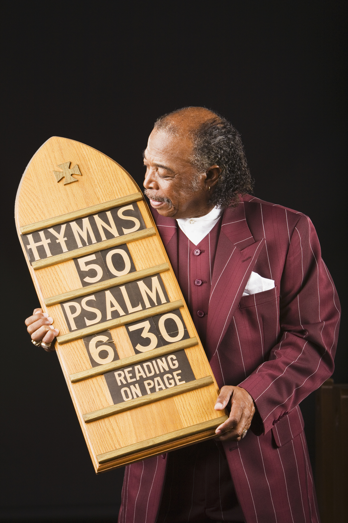 Senior African man holding hymn board