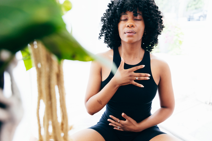 Black women relaxing doing breathing exercises