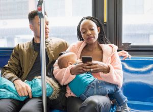 Young mother father and infant riding city bus