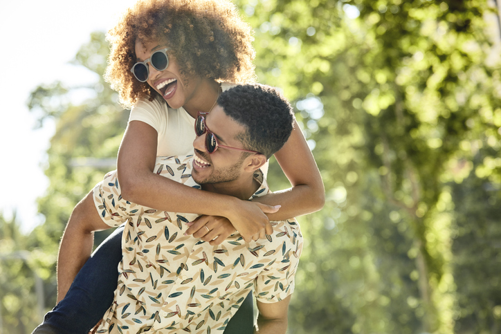 Cheerful young couple enjoying piggyback ride