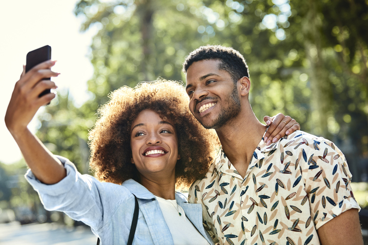 Couple taking selfie using mobile phone in city