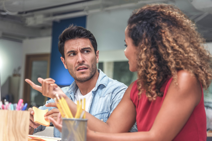 Businessman With Female Coworker During Meeting In Office