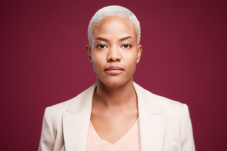 Studio headshot of a serious businesswoman wearing a suit.
