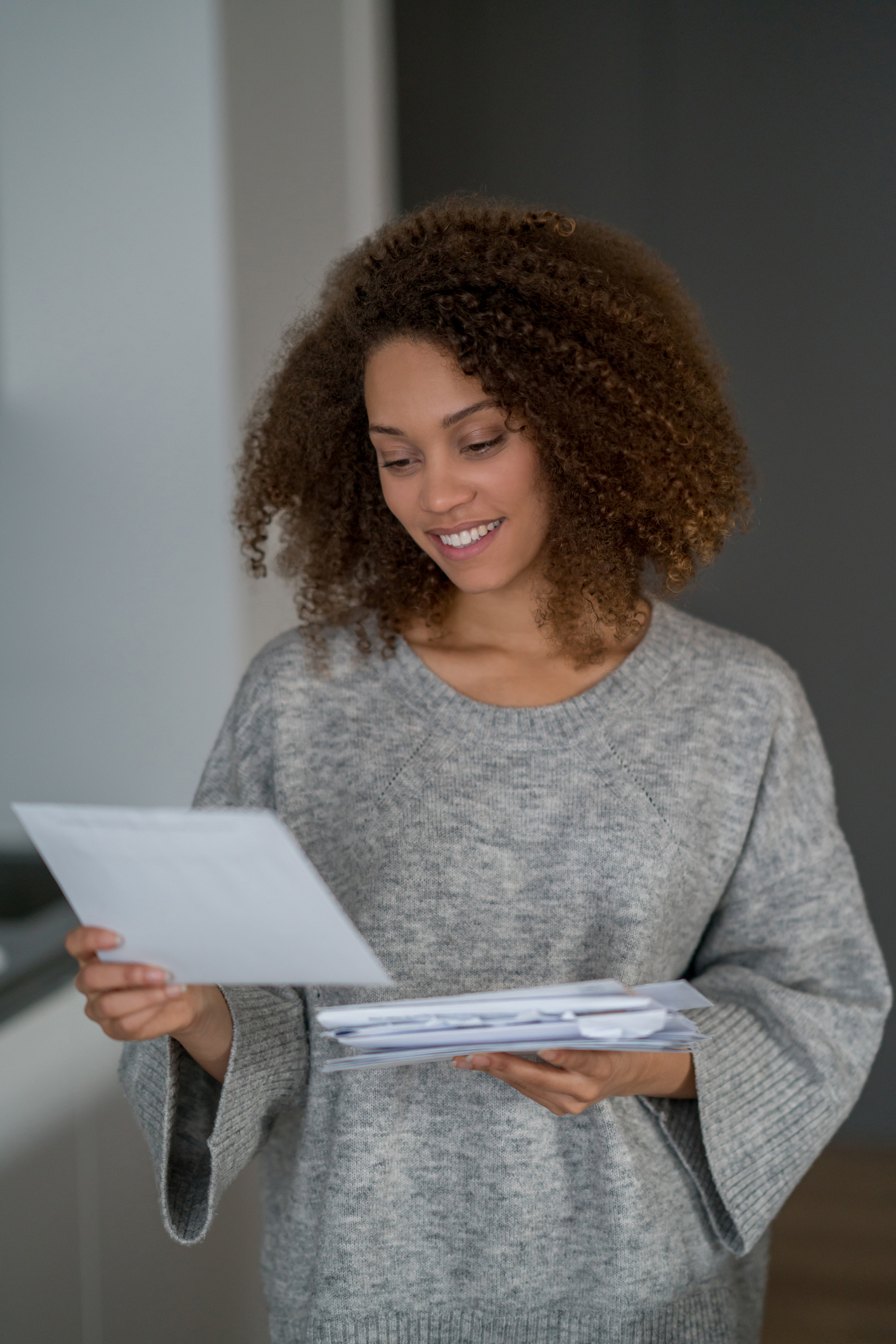 African American woman at home checking her mail