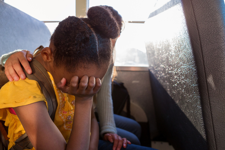 Young schoolgirl cries as her friend consoles her