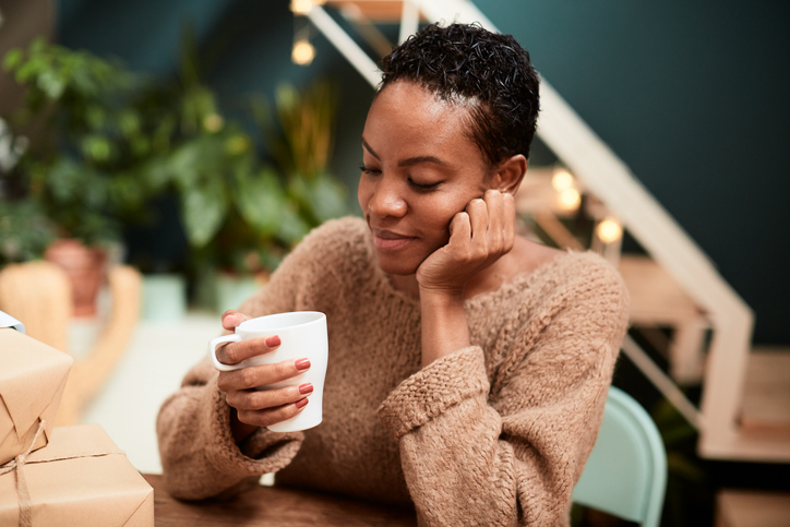 Woman relaxing with a cup of coffee at home.