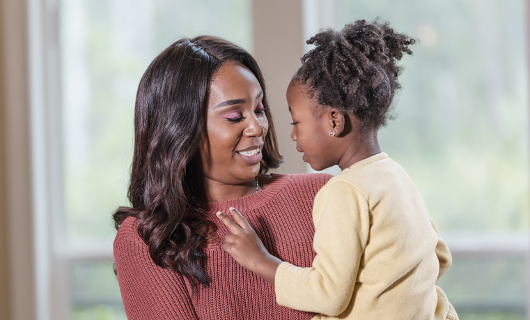 African-American mother holding young daughter