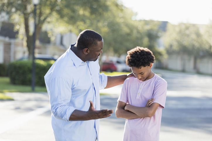 Father disciplining or giving advice to teenage boy