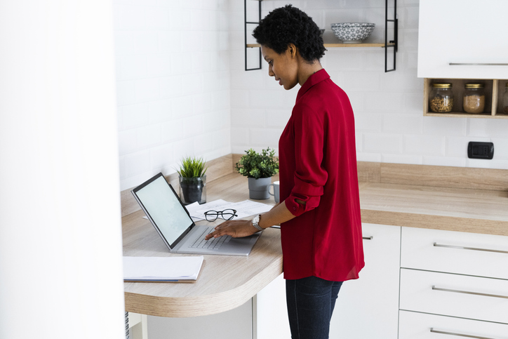 Young woman using laptop in kitchen at home
