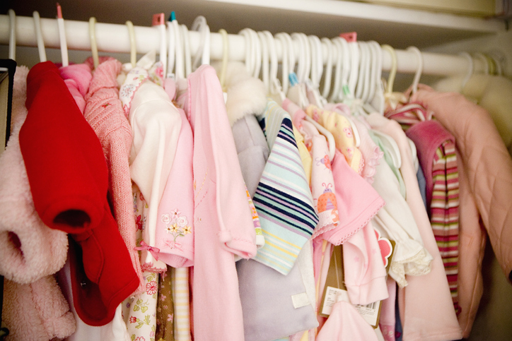 Baby girl clothing hanging in closet
