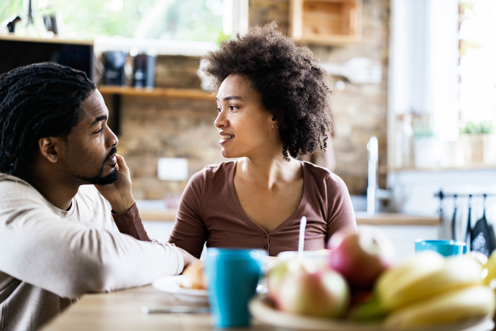 Loving African American couple talking in the kitchen.