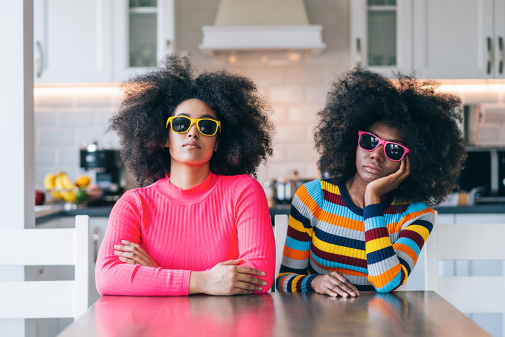 Two african women in colorful outfit sitting at home