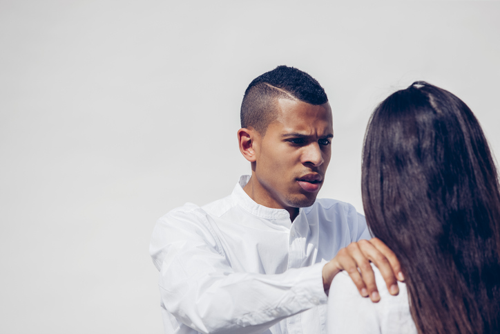 Portrait of angry young man face to cafe with his girlfriend in front of white background