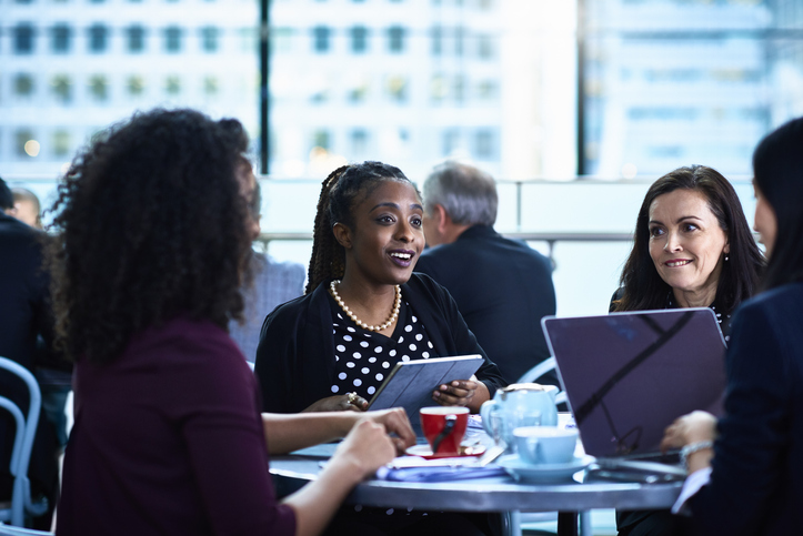 Female colleagues meeting and using digital devices