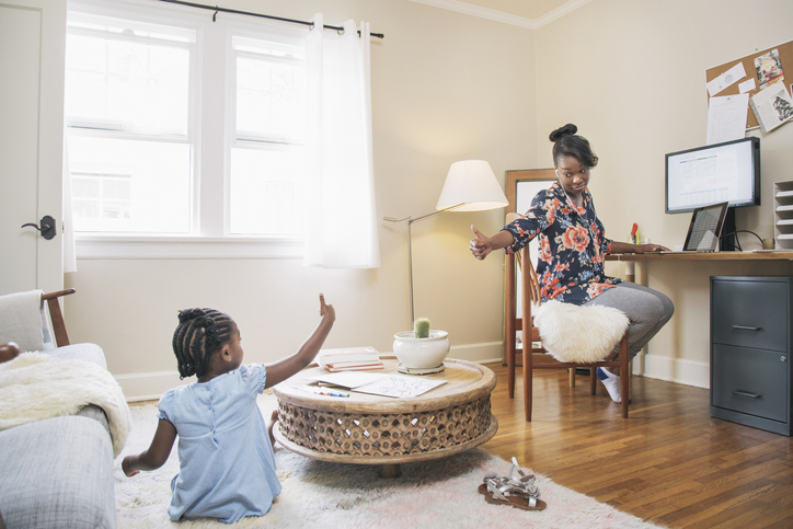 African American mother and daughter gesturing thumbs up