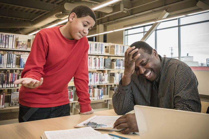 Teacher laughing with student in library
