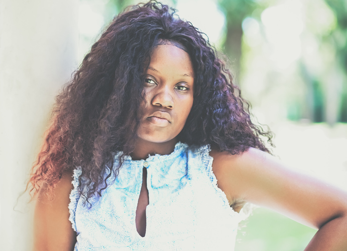 Vulnerable looking young adult female in defiant portrait