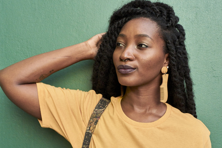 Portrait of young woman with nose piercing and dreadlocks