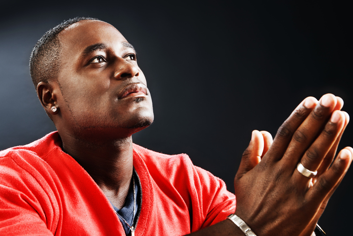 Young man prays devoutly, his hands folded